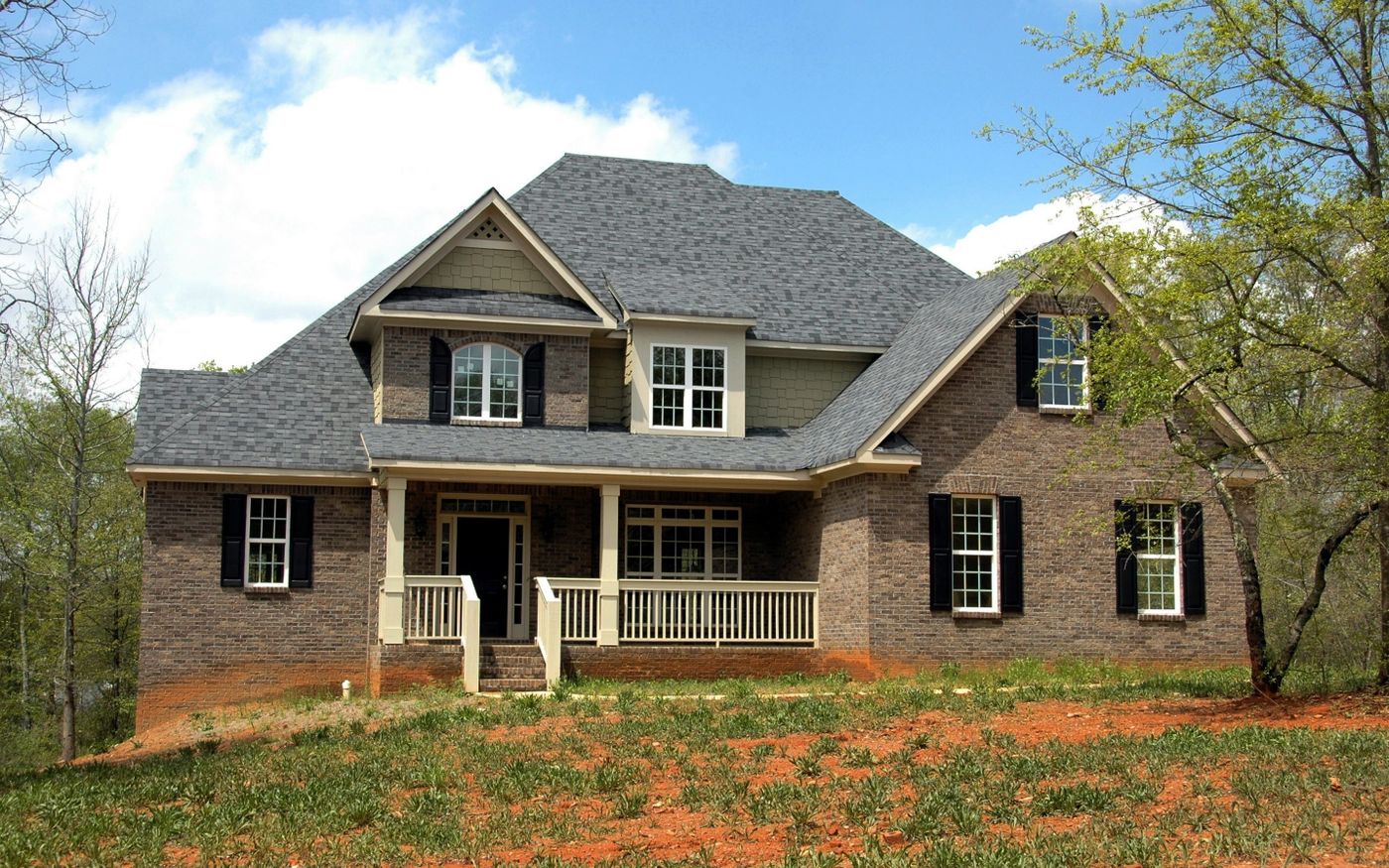 Brick house with grey shingled roof on a hillside